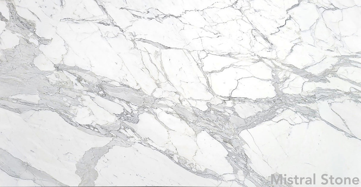 Premium Calacatta Extra marble slab featuring a luminous pristine white background with dramatic bold grey and pewter veining with customizable finishes by Mistral Stone