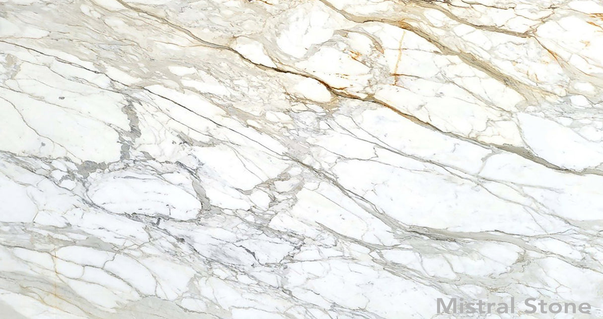 Premium Calacatta Gold marble slab featuring a luminous white background with dramatic grey and rich honey gold veining with customizable finishes by Mistral Stone