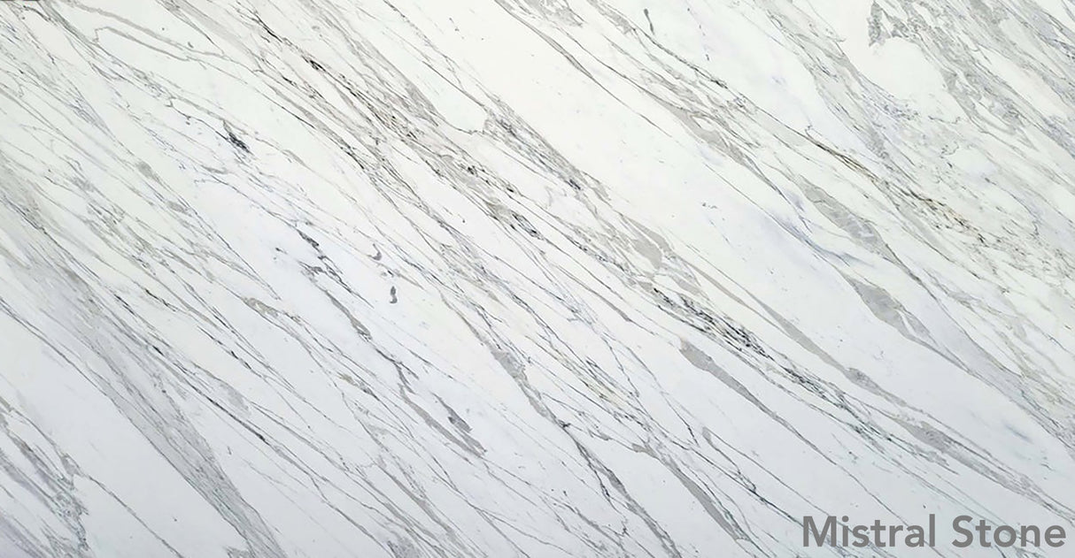 Calacatta premium Italian white marble slab featuring iconic bold diagonal grey veining on a luminous white background with customizable finishes by Mistral Stone
