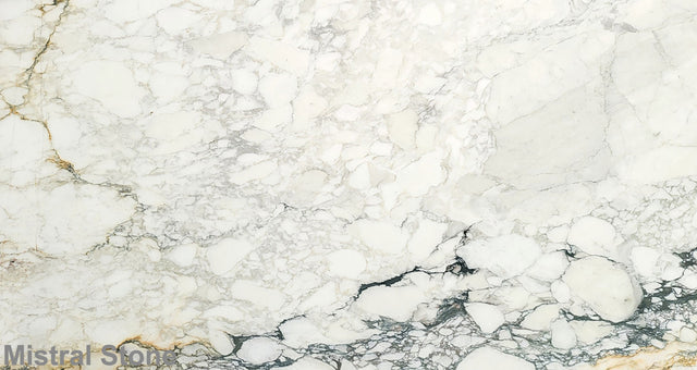 Premium Calacatta Soft Monet marble slab featuring a soft brecciated alabaster white canvas with subtle sage green, light gold, and charcoal grey pathways with customizable finishes by Mistral Stone